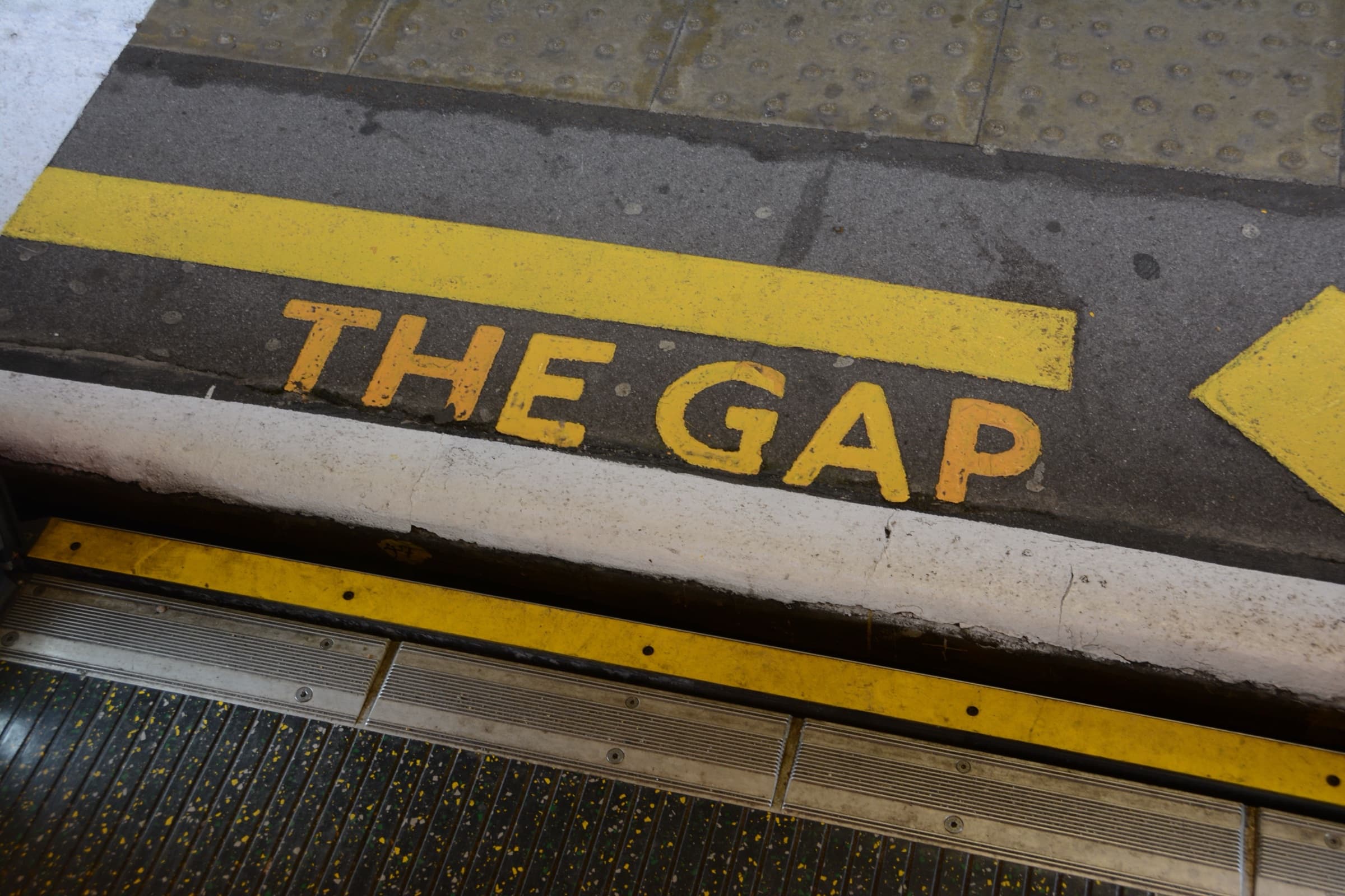 The words "The gap" painted in yellow at the edge of a train platform
